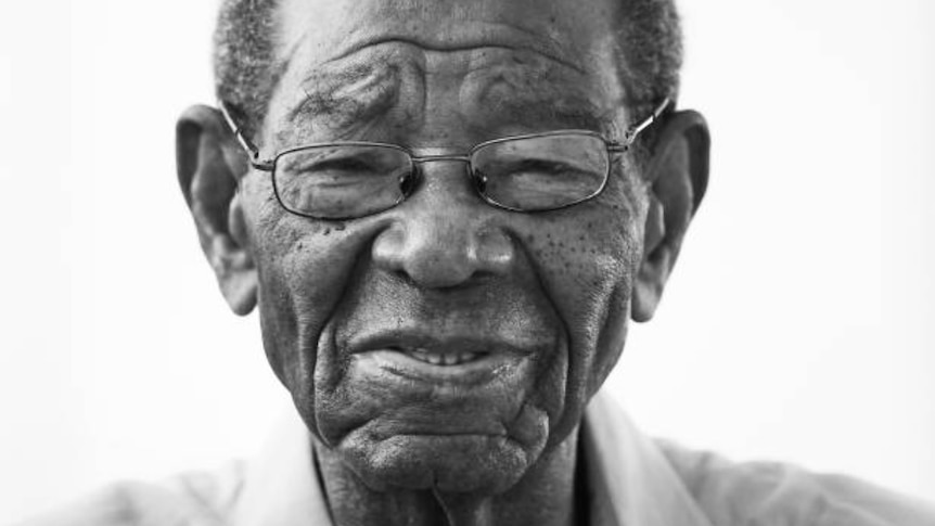 A close up portrait photo of Everton Weekes, who is looking down the camera