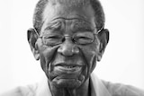 A close up portrait photo of Everton Weekes, who is looking down the camera