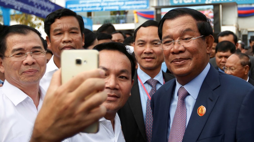 Cambodian Prime Minister Hun Sen poses for selfies with supporters.