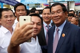 Cambodian Prime Minister Hun Sen poses for selfies with supporters.