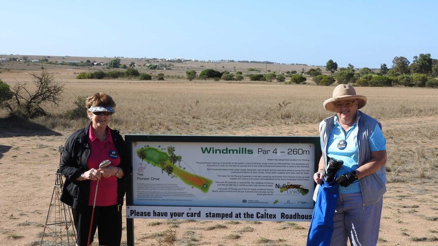 Two women stand on a golf course on the Nullarbor
