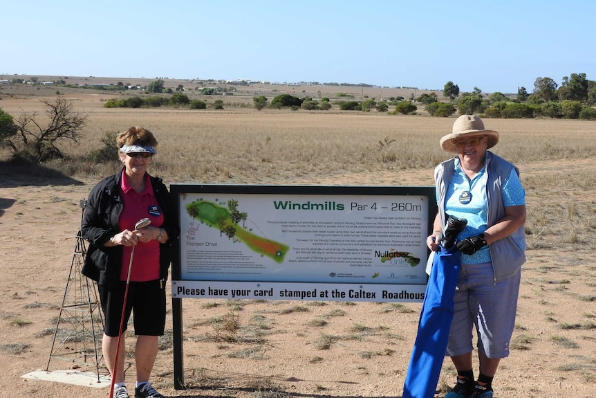 Two women stand on a golf course on the Nullarbor