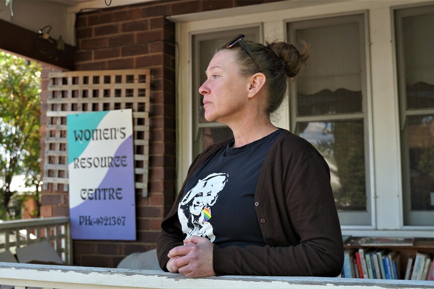 A woman in a black tshirt standing in front of a women's resource centre