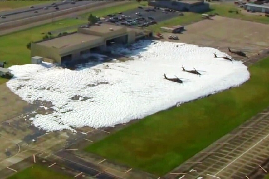 planes on the ground covered by and surrounded by a white foam or PFAS