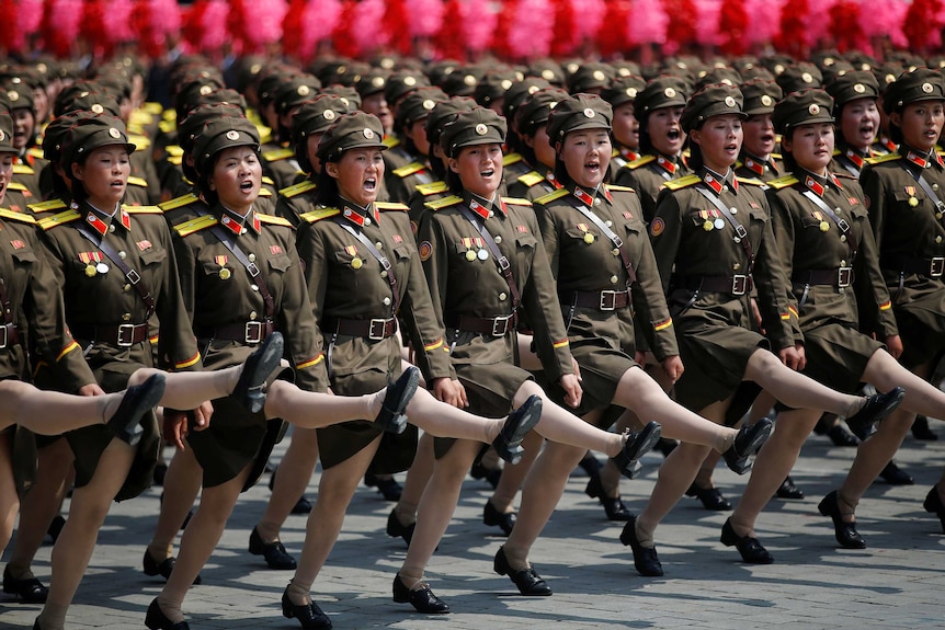 North Korean soldiers march and shout slogans during a military parade