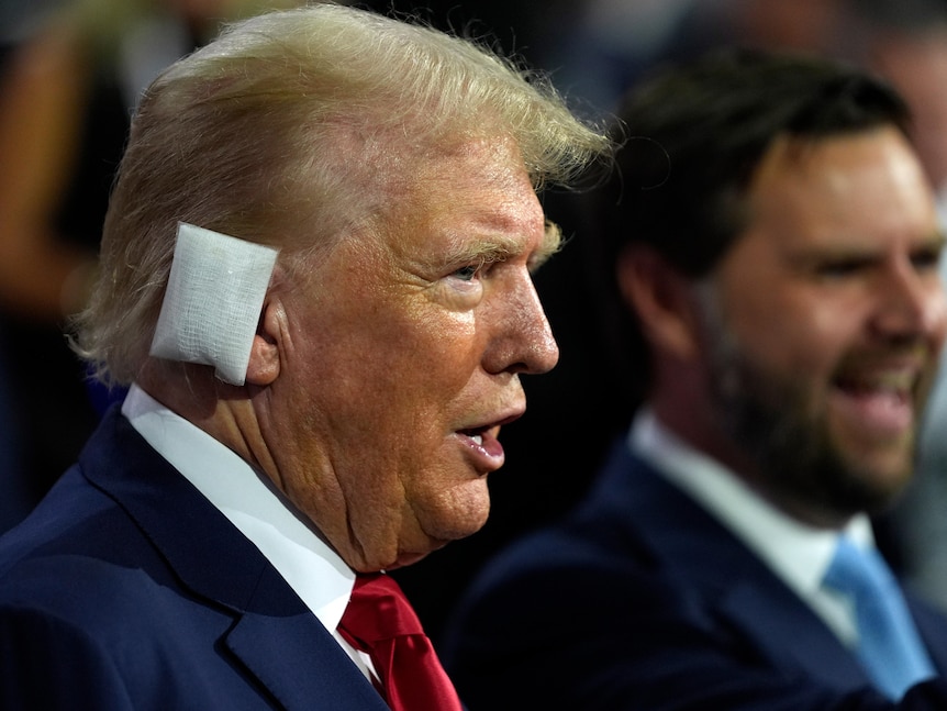 Trump with a bandage over his ear in a suit.