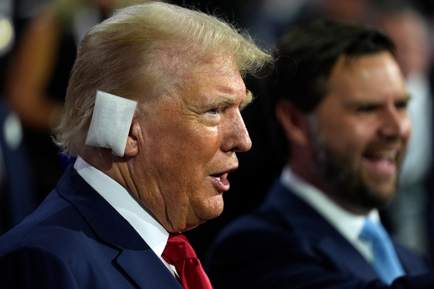 Trump with a bandage over his ear in a suit.