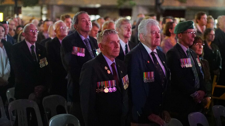 People watch an Anzac Day ceremony in Brisbane