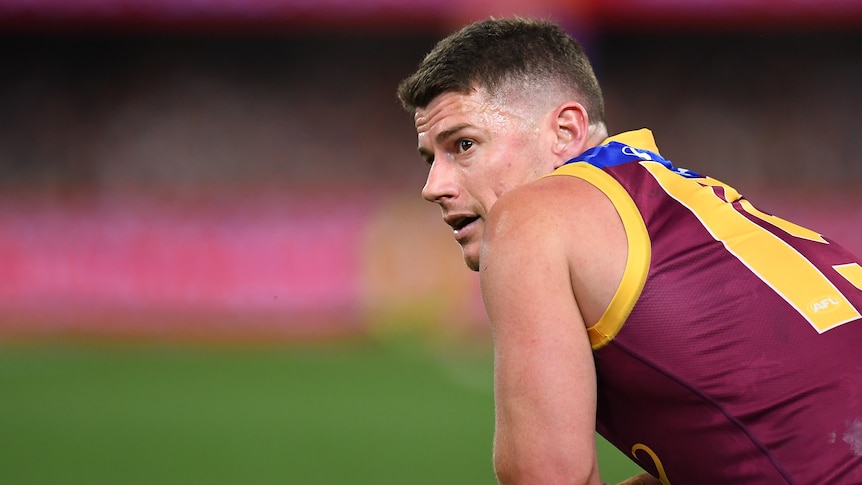 Dayne Zorko looks over his shoulder while on his haunches