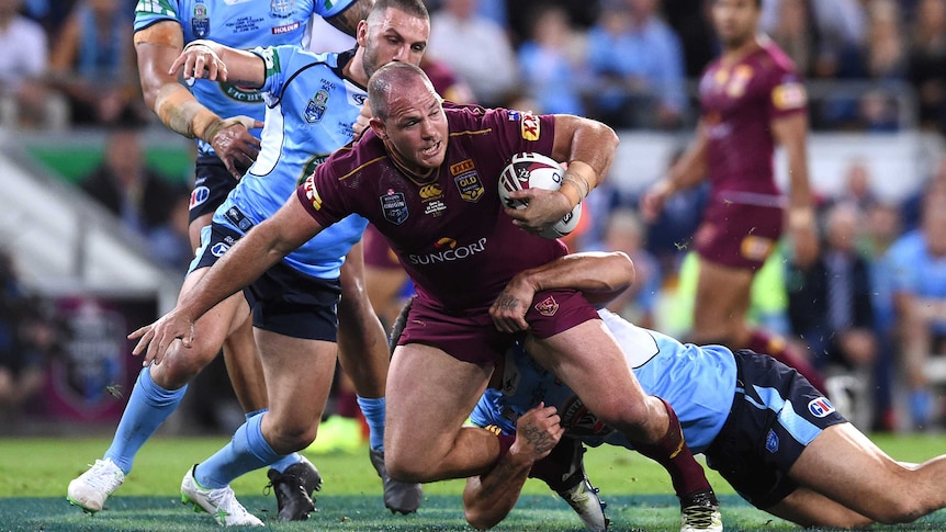 Matt Scott of the Queensland Maroons (C) is tackled by NSW in Origin II, 2016.