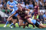 Matt Scott of the Queensland Maroons (C) is tackled by NSW in Origin II, 2016.