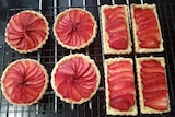 Strawberry tarts on a wire rack before going in the oven.