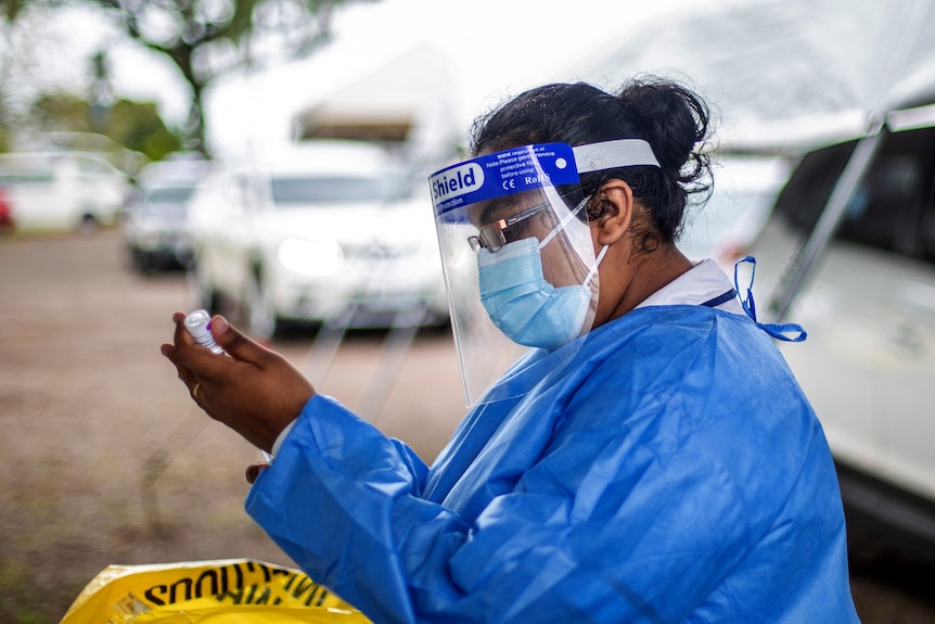 A health worker in Fijian capital Suva draws from a vial of AstraZeneca while in full PPE. 