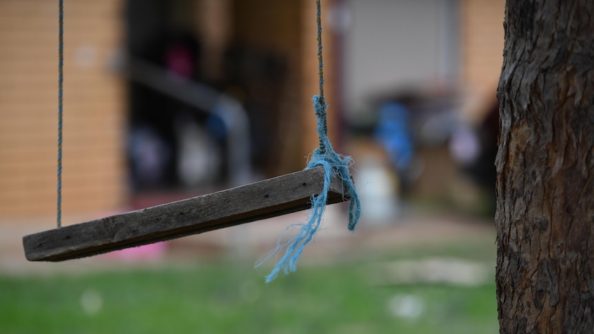 A wooden swing with blue string