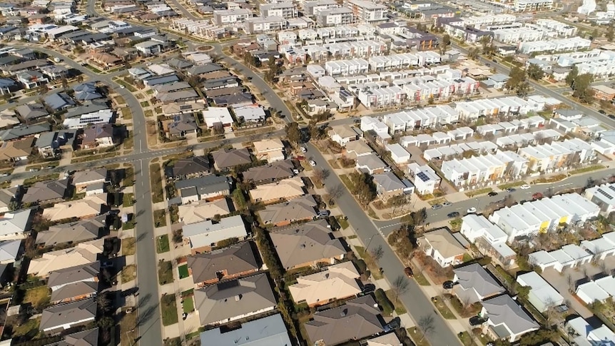 An aerial view of a new suburb with lots of townhouses and apartments.