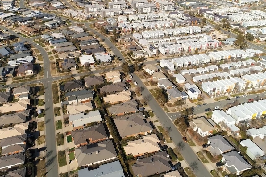 An aerial view of a new suburb with lots of townhouses and apartments.