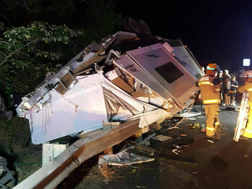 Night picture of a caravan destroyed after a crash on a road.