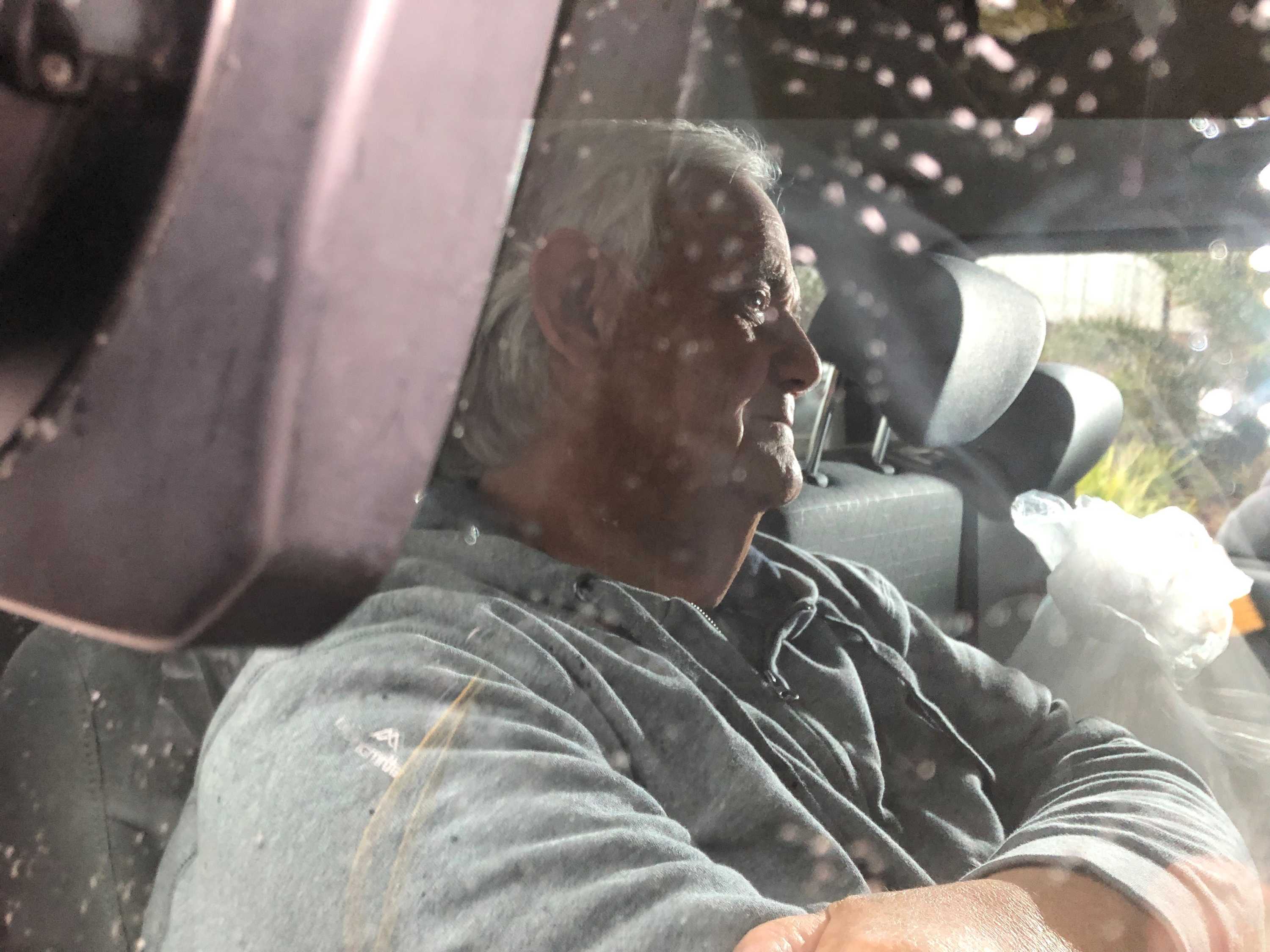 Berwyn Rees sits in the back of a car, looking away from the camera