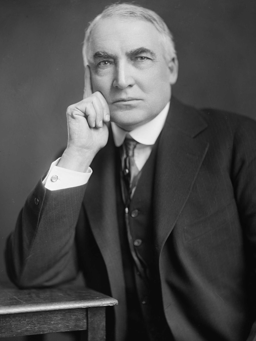 A man sits for a black and white portrait