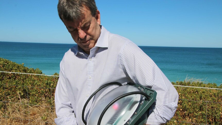 WA Fisheries Minister Dave Kelly demonstrates the SMART drum line technology that will be installed off Gracetown.