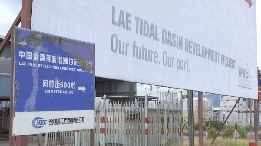 A blue sign points towards the Lae Tidal Basin Development in PNG.