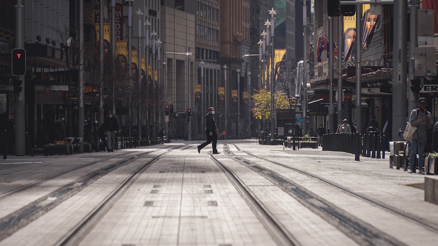 A man walks across an empty city street