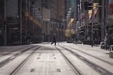 A man walks across an empty city street