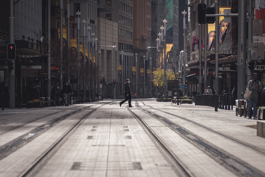 A man walks across an empty city street