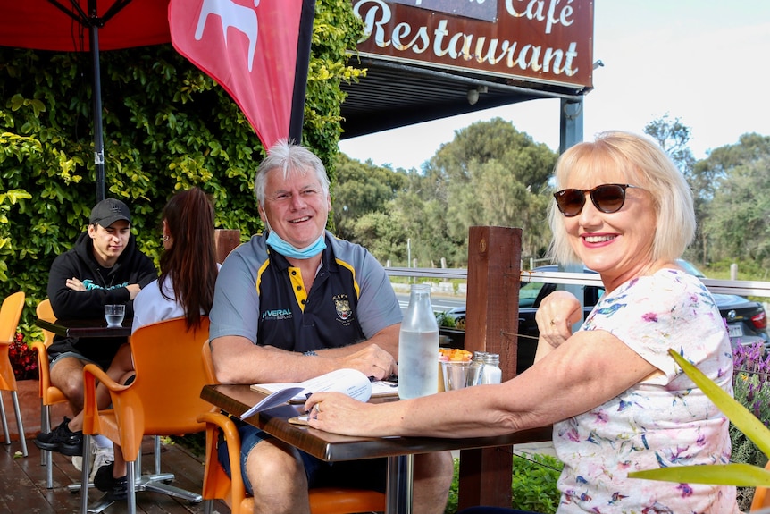 A couple seated outdoors at a cafe.