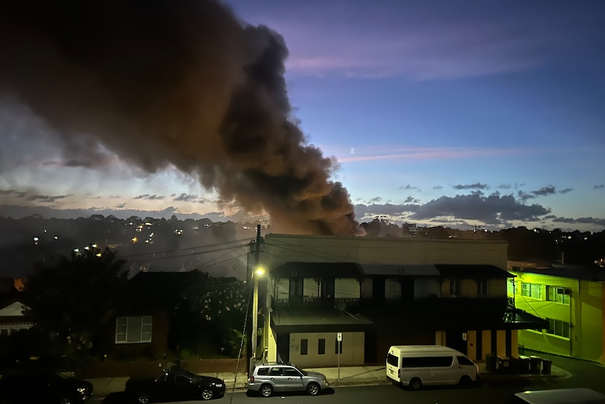 Smoke from a fire in a warehouse as seen from a resident's balcony