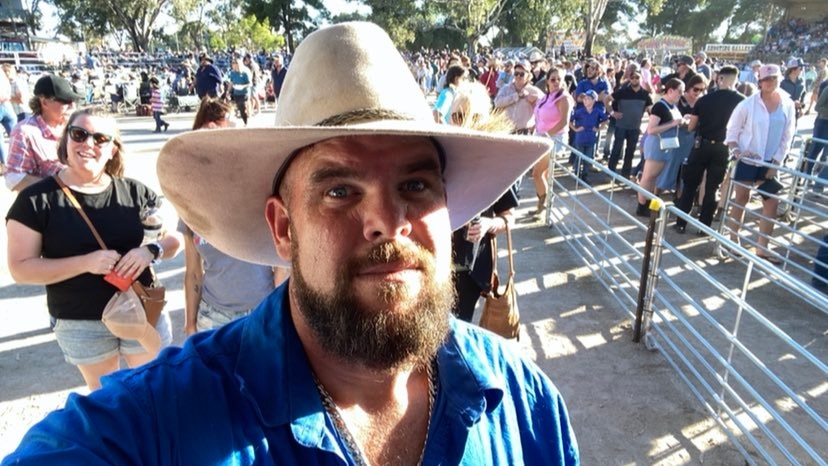 A man in a blue shirt with an akubra hat.