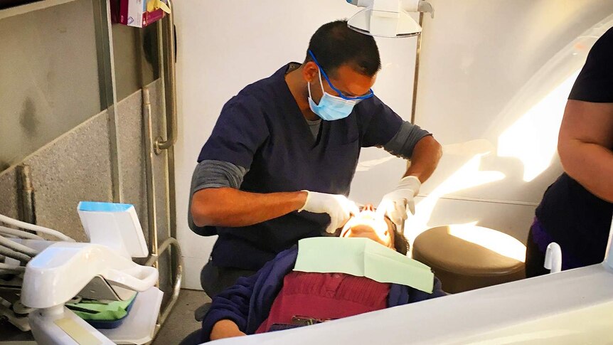 Dentist Dr Jalal Khan treats a patient in his mobile dental surgery truck in far south-west Queensland.