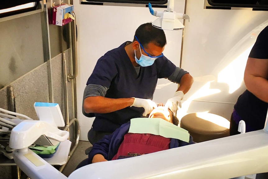 Dentist Dr Jalal Khan treats a patient in his mobile dental surgery truck in far south-west Queensland.