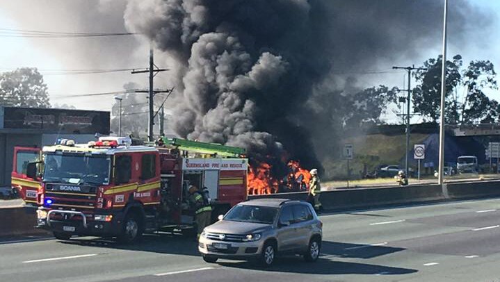 Truck on fire on the M1 at Logan, with firefighters at scene, south of Brisbane