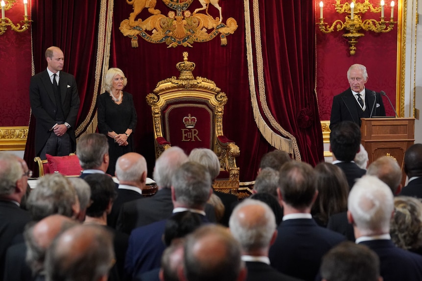 Il re Carlo III parla mentre Camilla e il principe William guardano il St James's Palace durante la sua cerimonia di adesione