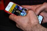 A person using a mobile phone with the Grindr app displayed