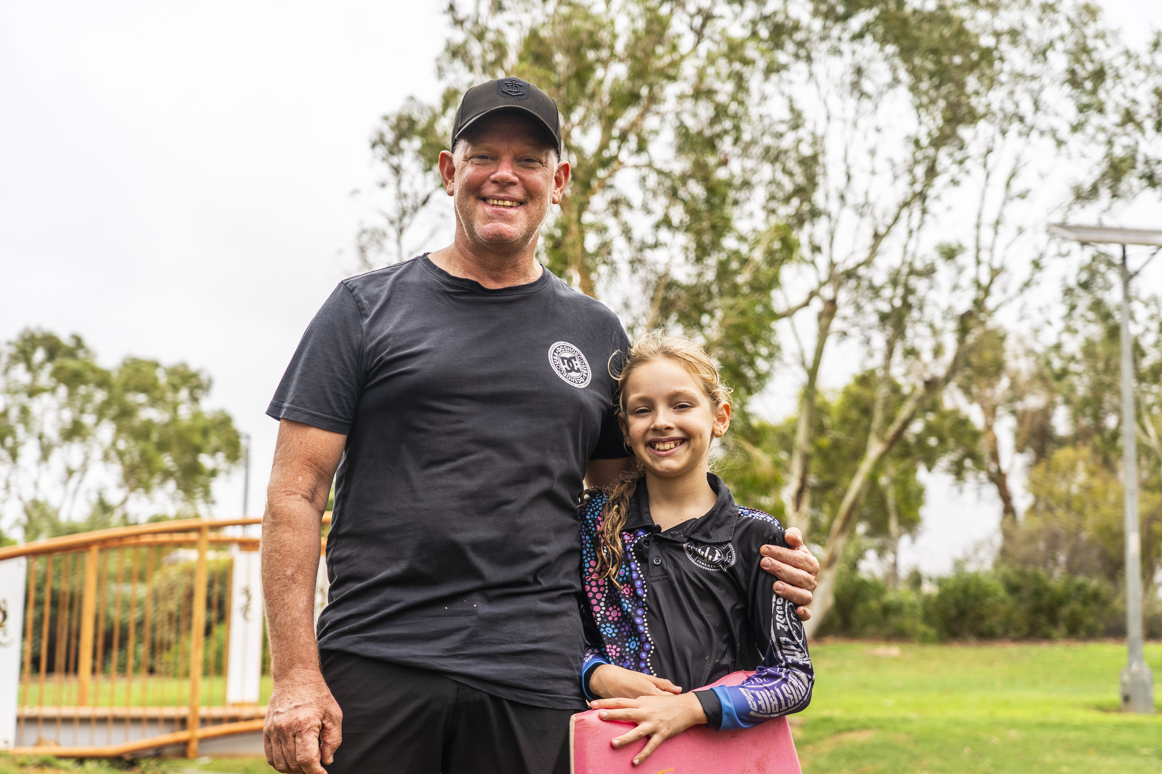 Un hombre con una camisa oscura con una chica con una tabla de boogey.