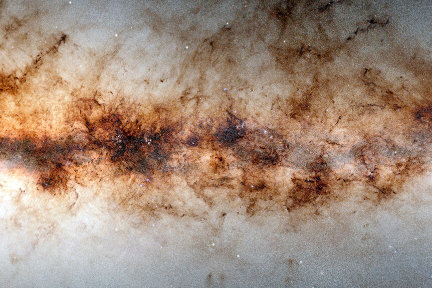 A brown line of stars and galaxies runs across an image of a night sky