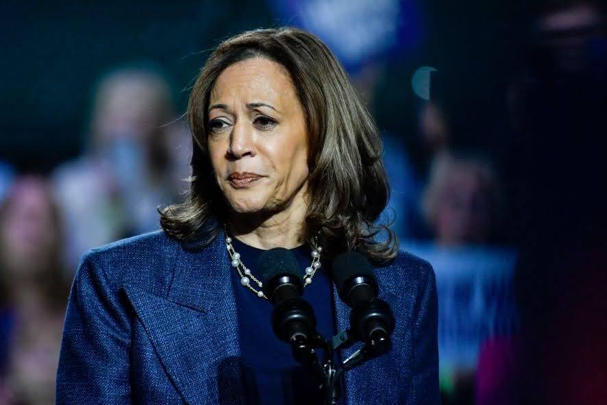 kamala harris wearing navy suit looking to the side with slightly worried expression