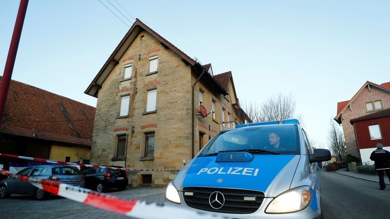 A police van is seen in a cordoned-off area, in front of a house in Rot am See, Germany.