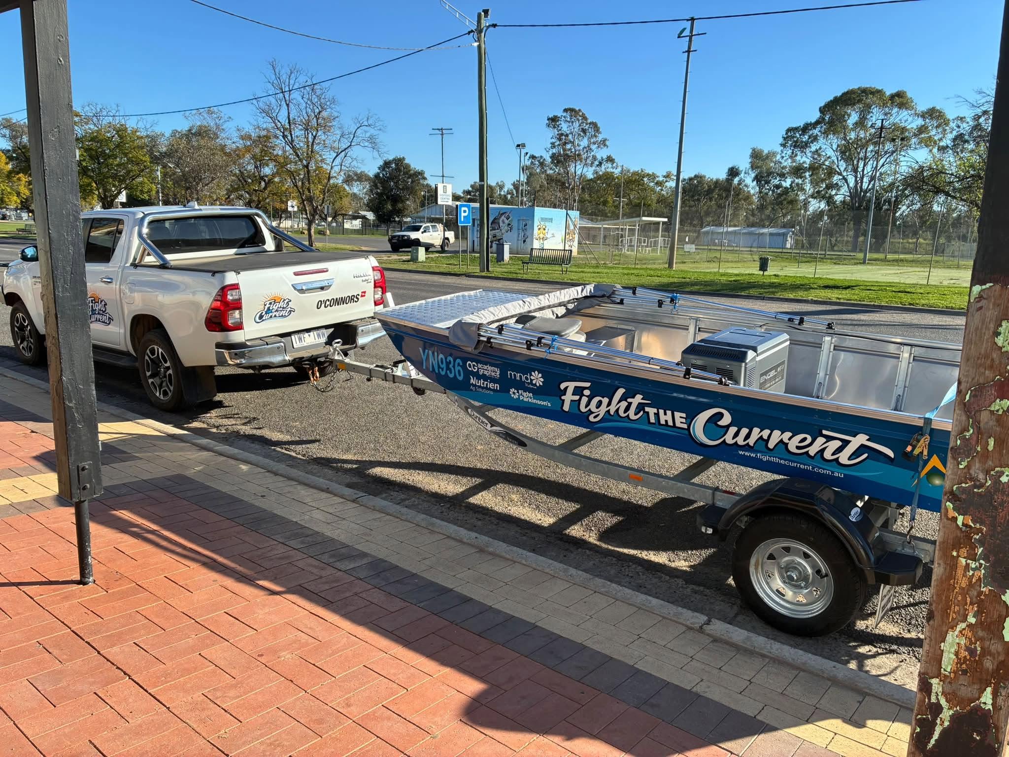 A tin boat attached to the back of a ute.