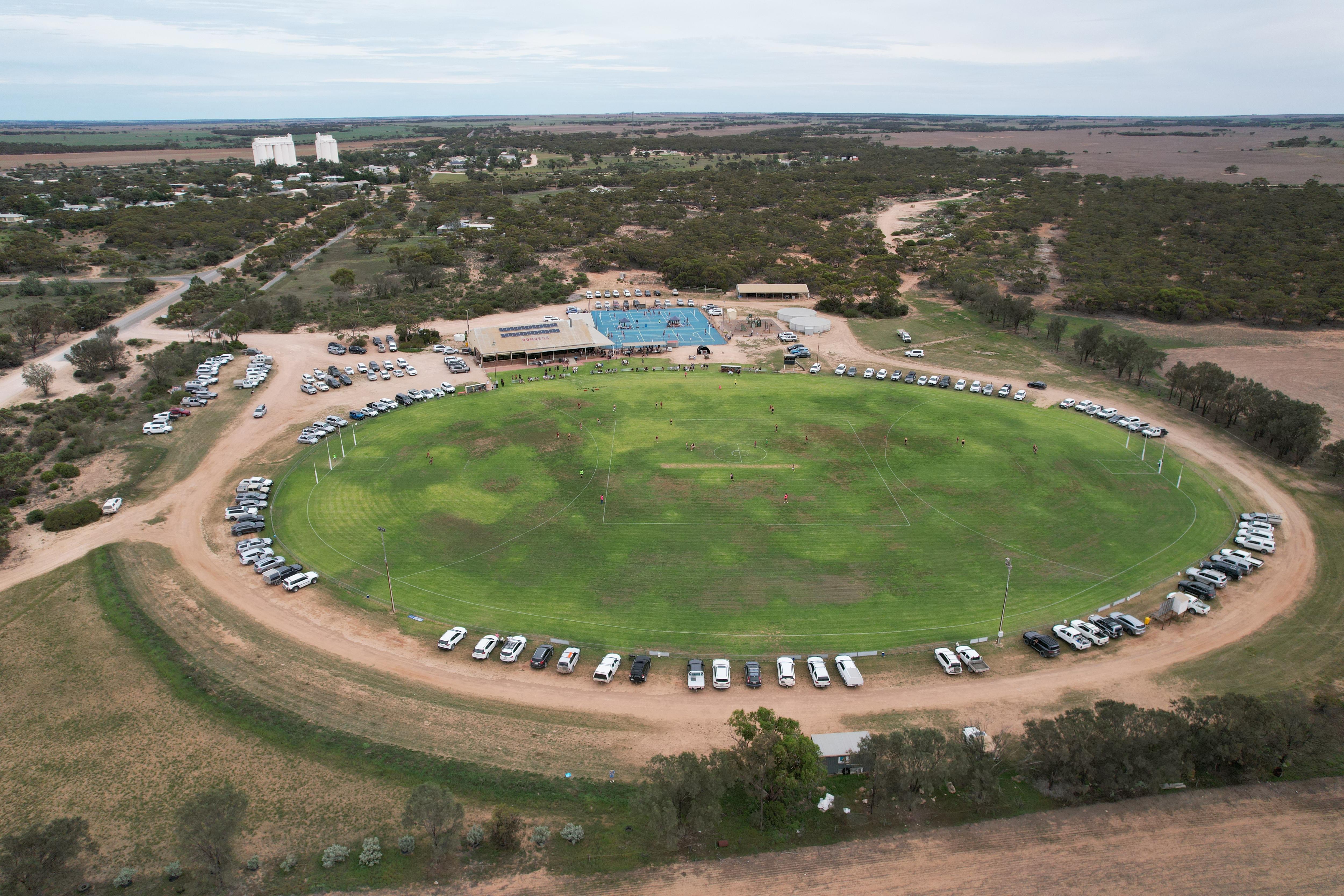 Tiro de drone de quadras verdes ovais e de netball e silos da cidade 