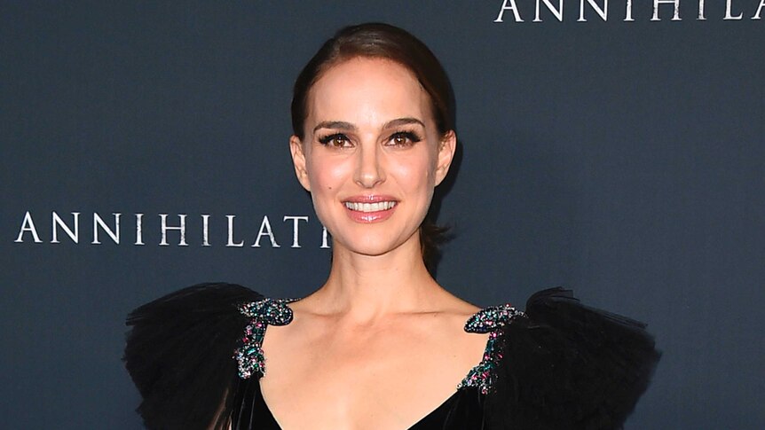 Actress Natalie Portman is seen posing for a photo at a premiere of her film 'Annihilation', wearing a black dress.