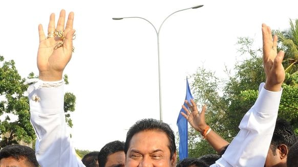 Sri Lankan President Mahinda Rajapakse acknowledges cheers from his supporters