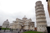The Leaning Tower of Pisa (Torre di Pisa) is seen at right next to the medieval cathedral of Pisa.