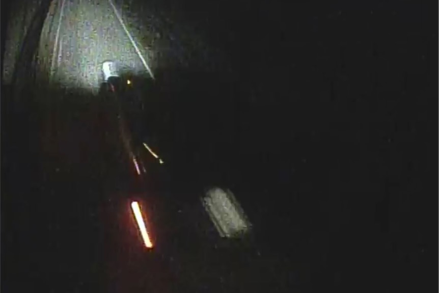A blurred shot of a car driving along a road at night