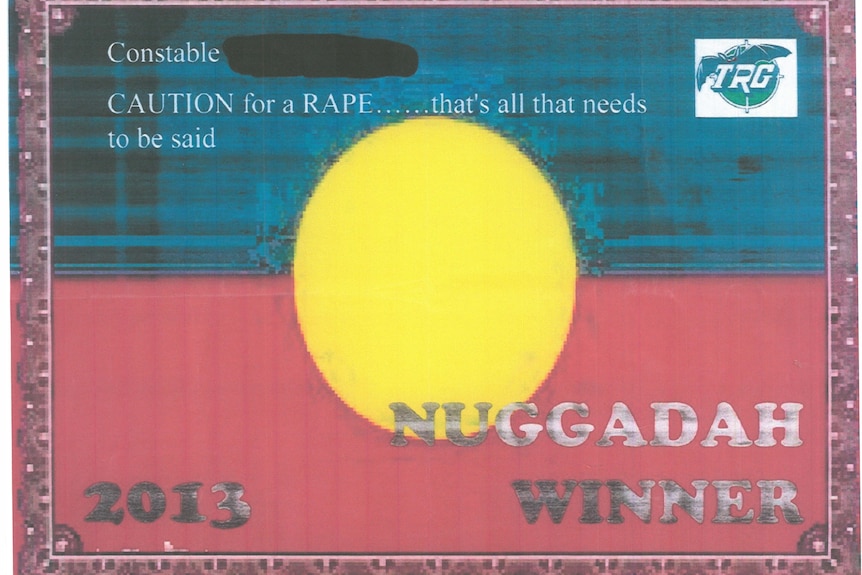 A certificate reads 'caution for rape ... that's all that needs to be said' in front of an Aboriginal flag and dated 2013.