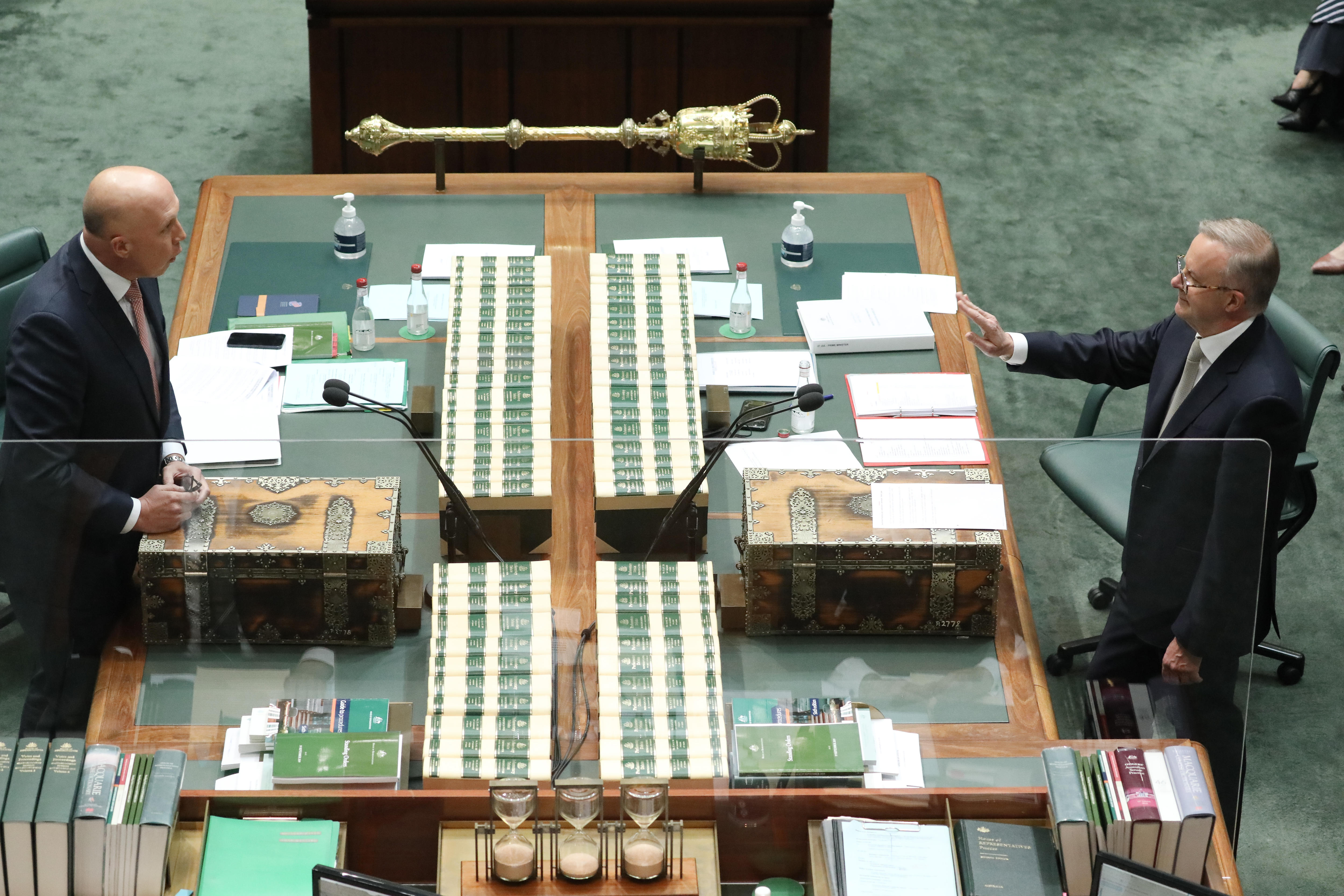 Peter Dutton and Anthony Albanese stand and talk at each other across a table in the house of representatives