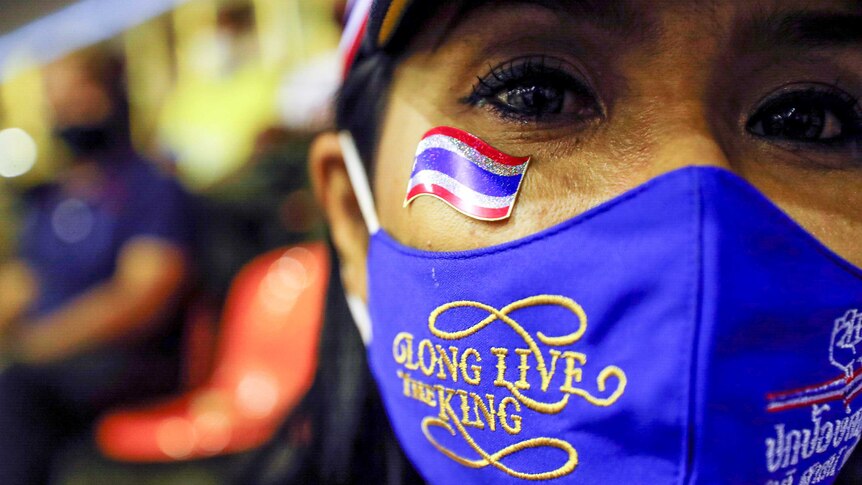 A woman in a facemask which reads: "long live the king"