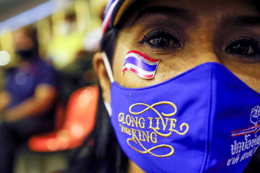 A woman in a facemask which reads: "long live the king"